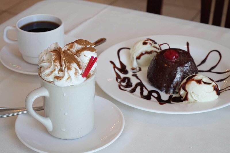 Coffee drink with whipped cream and a chocolate lava cake