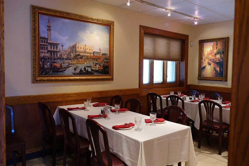 Dining room with set tables and walls decorated with paintings